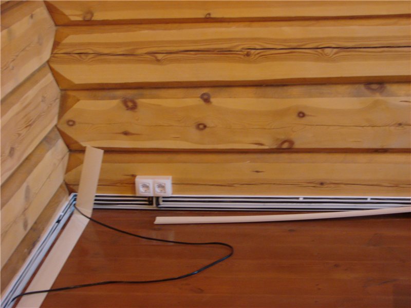 процесс монтажа плинтусных кабель-каналов в деревянном доме